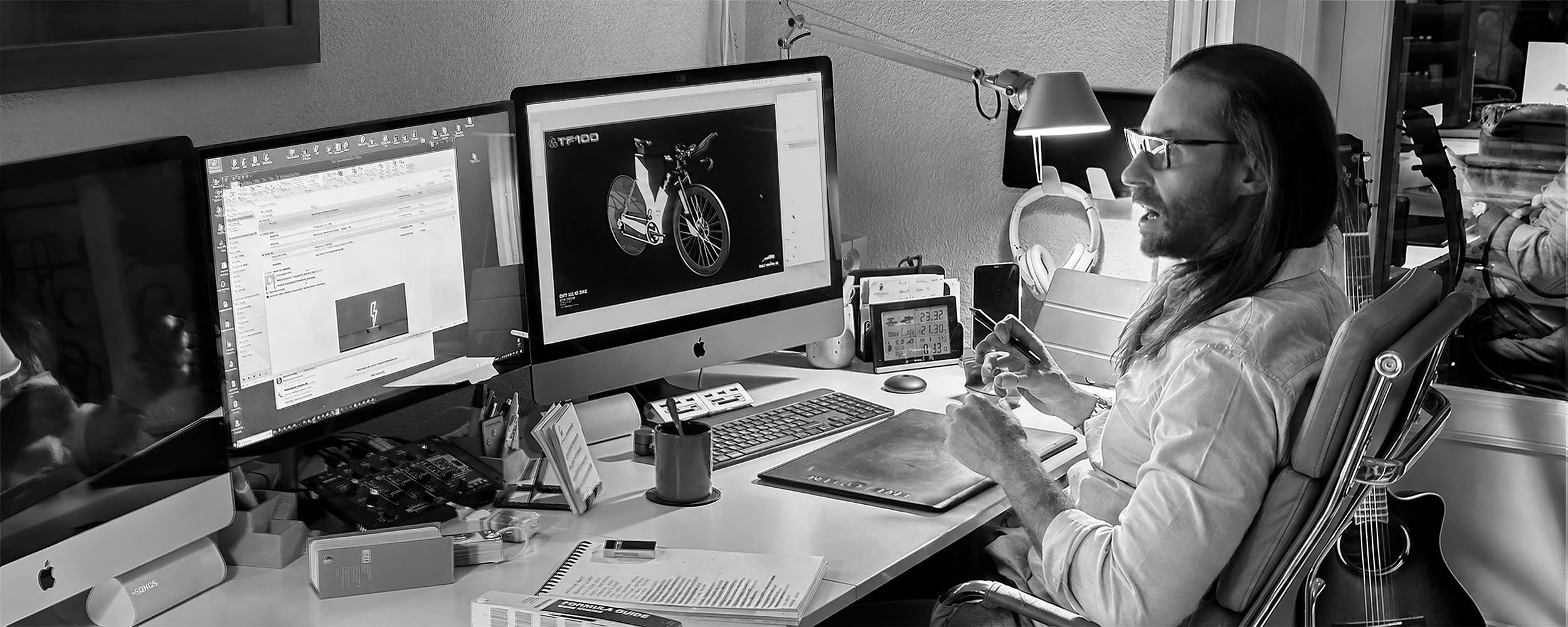 Matías García Posadas at his studio desk, reviewing a Kú Cycle bike CAD model across multiple monitors, black and white