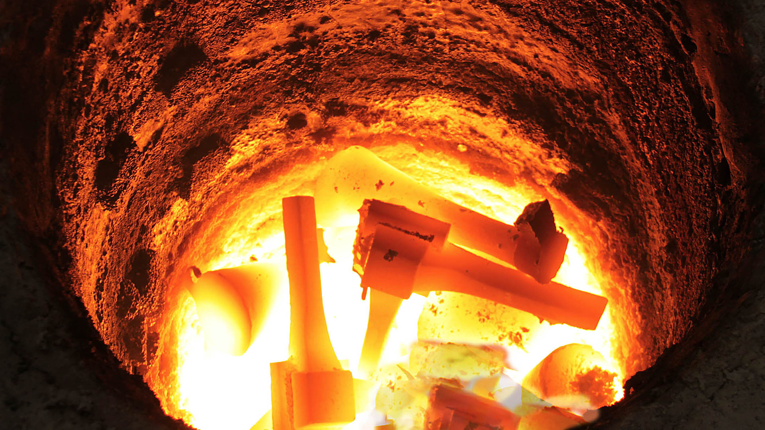 Tools inside the glowing furnace during casting