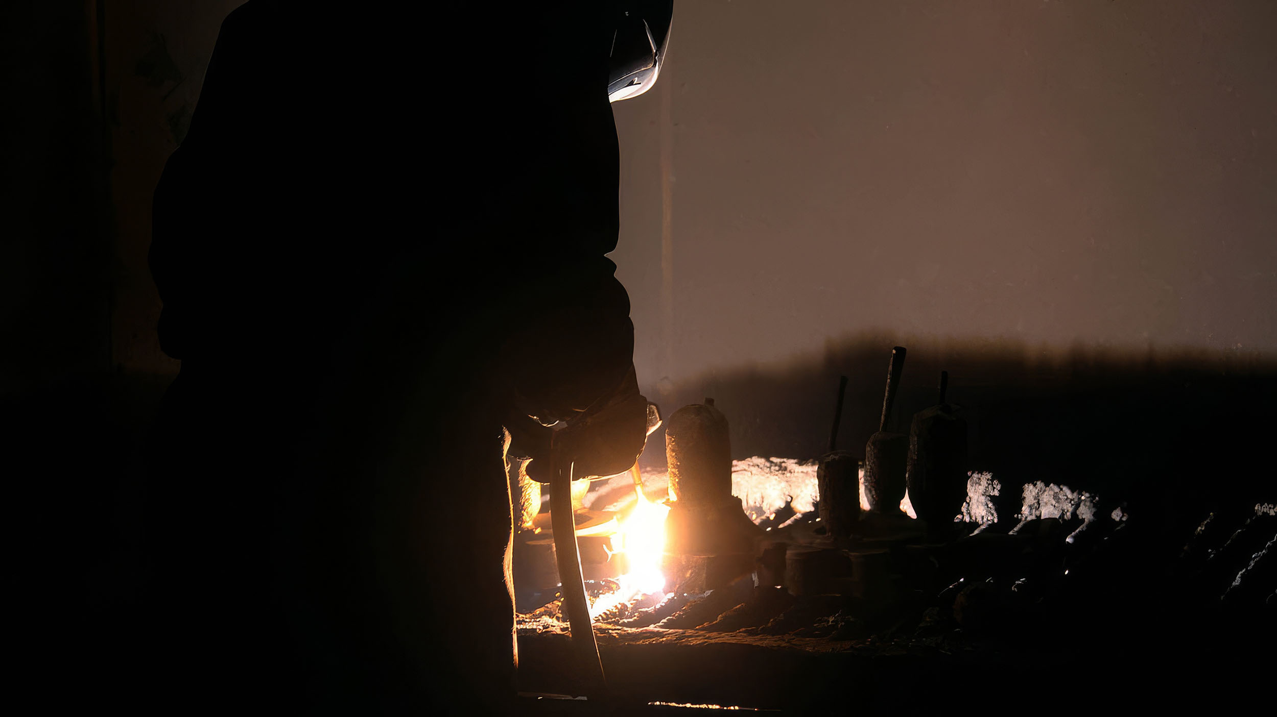Worker silhouette against the foundry furnace glow