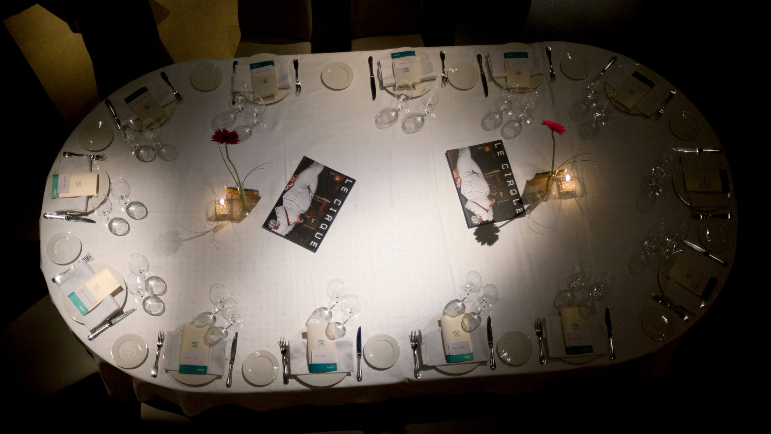 Le Cirque launch dinner — table setting with magazine place cards, overhead view