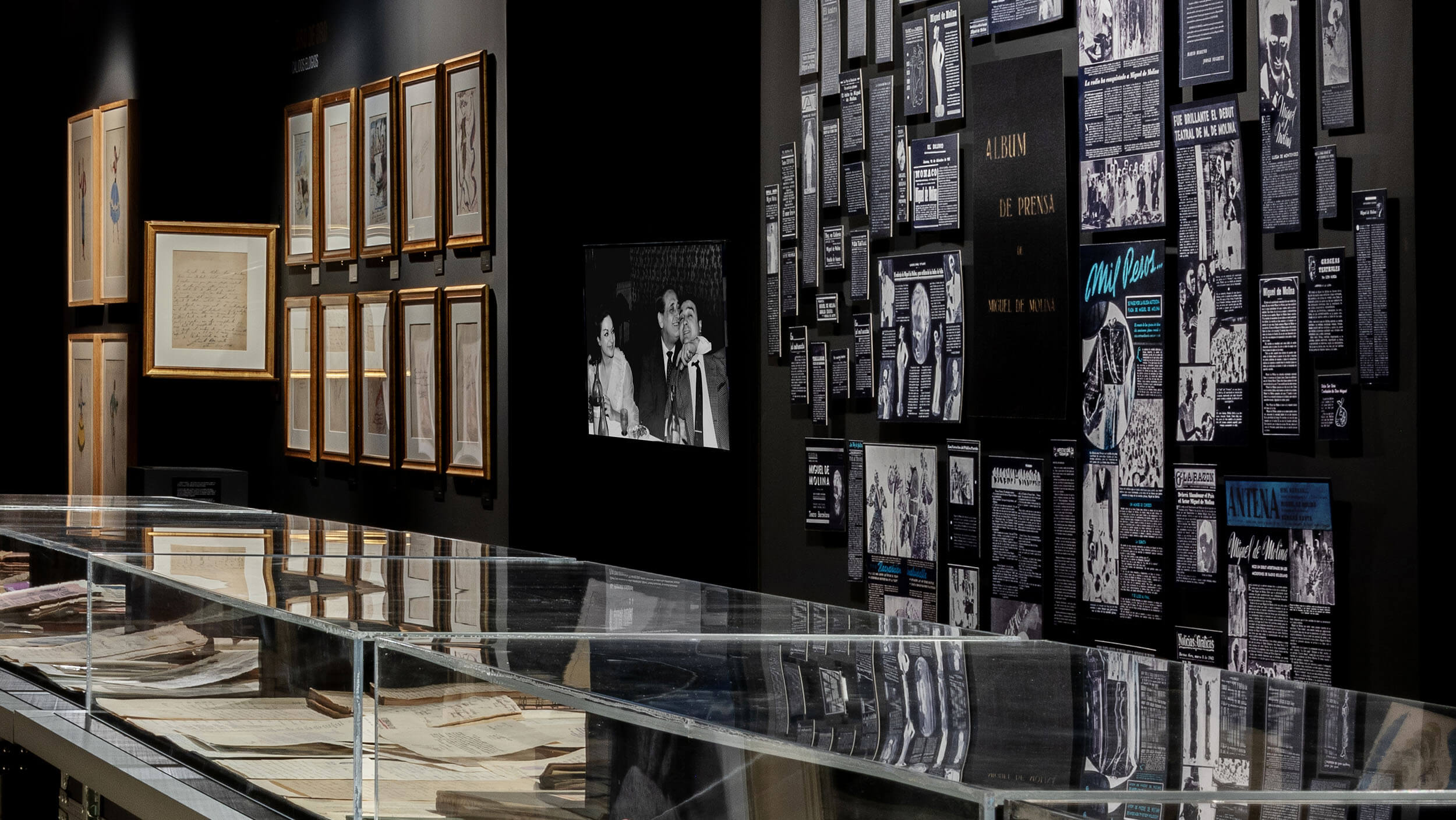 Archive vitrine display case — framed press clippings and photographs